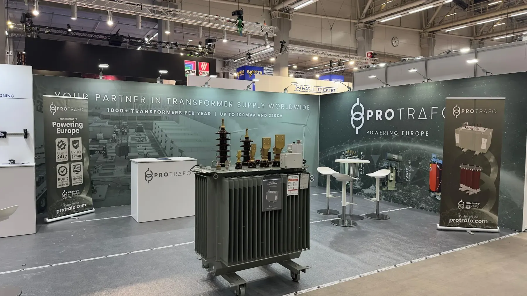 The Protrafo stand at Sähkö-Electricity 26 in Helsinki, with an oil-immersed distribution transformer in front of the "Powering Europe" wall